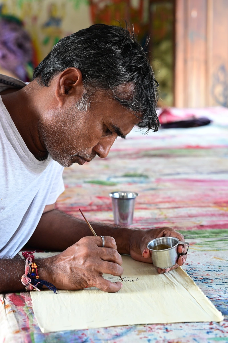 Ahmedabad pendant la période de Holi, Gujarat. Artisan local dessine des motifs traditionnels, illustrant le riche savoir-faire artisanal de la région lors du circuit.