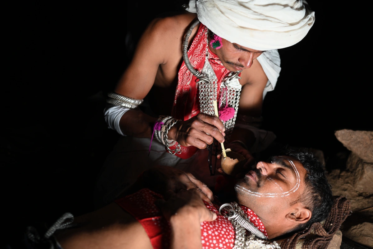 Préparatifs de la nuit précédant le festival de Kawant à Chhota Udepur, Gujarat : des hommes tribaux se décorent avec des tatouages blancs naturels – immersion culturelle et voyage durable