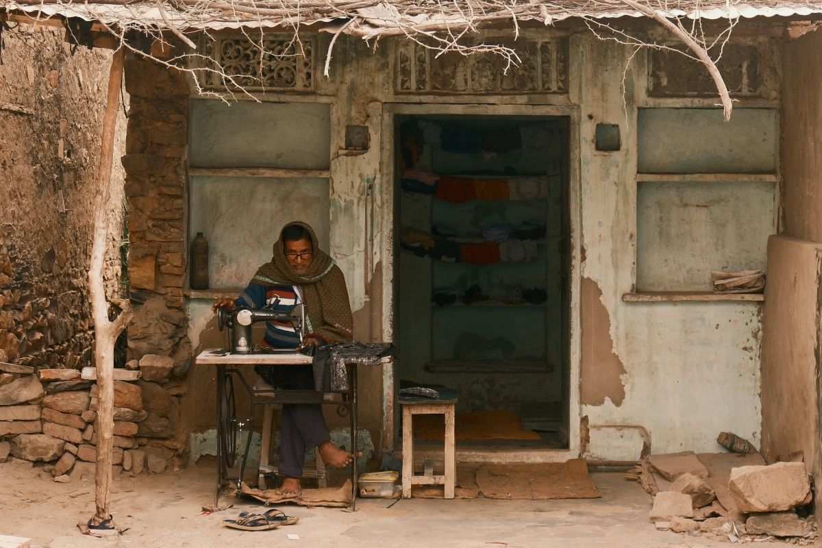 Tailleur local travaillant à la main dans le village authentique d’Ajabgarh au Rajasthan, symbole des traditions vivantes et du charme rural de l’Inde.