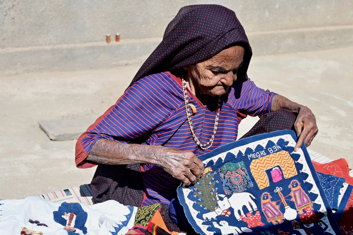 Artisan tribal créant des broderies traditionnelles colorées dans un village du Kutch.