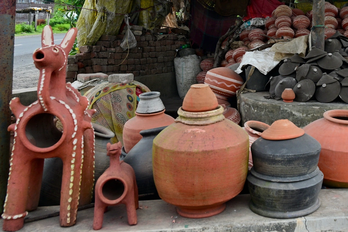 Un artisan fabriquant des chevaux en terre cuite et des figurines votives dans un village de potiers traditionnel en Inde.